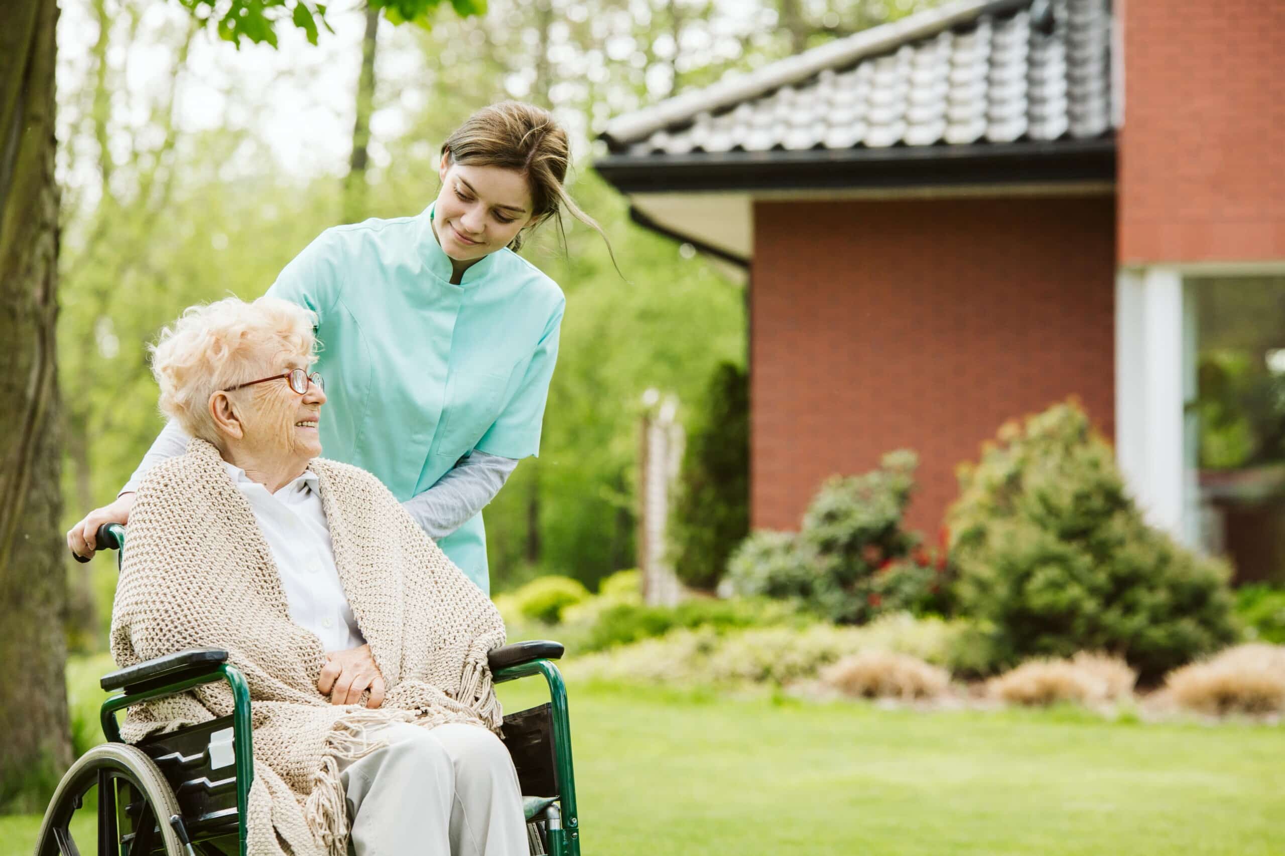 senior disabled woman with caregiver in the garden